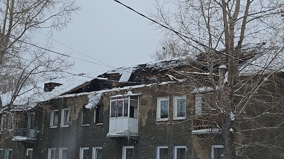 Специалисты управляющей компании и Кемеровской службы спасения работают на месте повреждения кровли двухэтажного жилого дома на улице Спартака, 26 в Кировском районе
