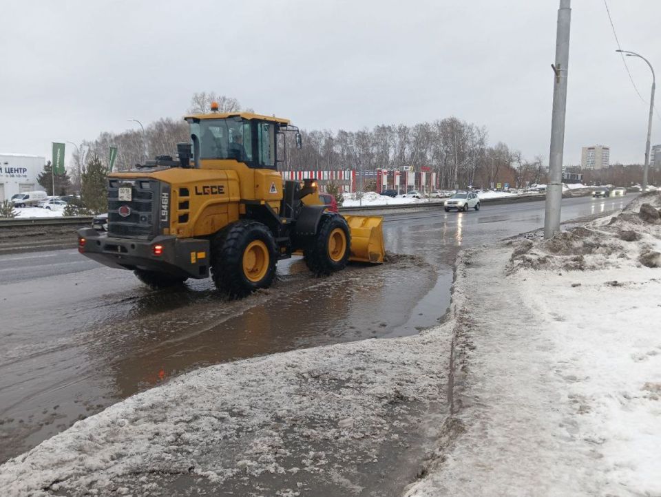 В Кемерове с помощью фронтальных погрузчиков убирают с дорог талую воду